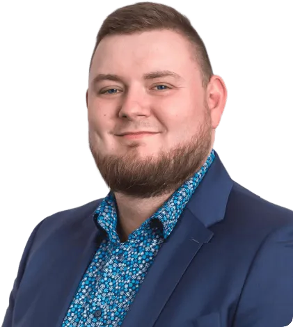 Ansprechpartner – junger Mann mit kurzen braunen Haaren und Bart mit blau gemustertem Hemd und blauem Jacket